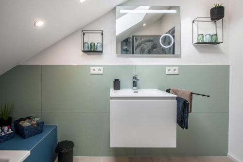 ein Bad mit einem Waschbecken und einem Spiegel in der Unterkunft Gold Haus in Weilheim
