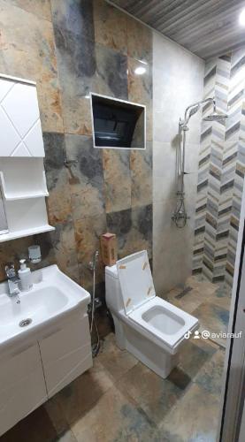 a bathroom with a white toilet and a sink at GoldenPirshaghi in Pirşağı