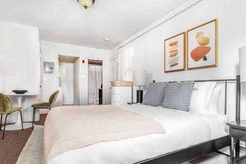 a white bedroom with a bed and a desk at Back Bay Studio steps from Newbury T BOS-557 in Boston
