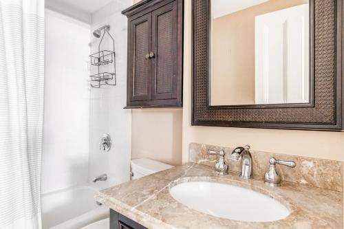 a bathroom with a sink and a mirror and a tub at Back Bay Studio steps from Newbury T BOS-557 in Boston