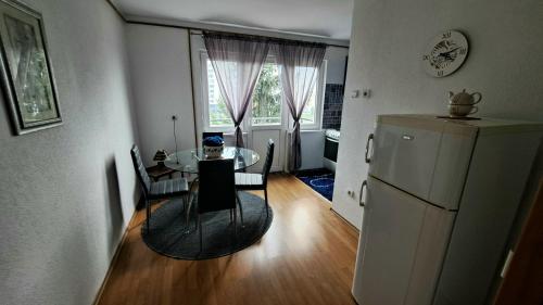 een keuken en eetkamer met een tafel en een koelkast bij Apartman Bella Ilidža in Sarajevo