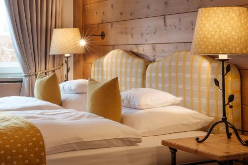a hotel room with two beds and a lamp at Sonnenalp Resort in Ofterschwang