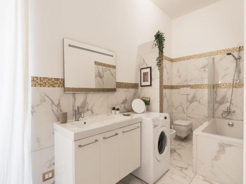 ein weißes Badezimmer mit einem Waschbecken und einer Waschmaschine in der Unterkunft The Best Rent - Bright flat near San Pietro in Rom