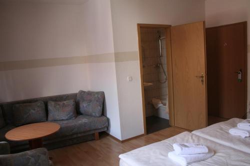 ein Wohnzimmer mit einem Sofa und einem Tisch in einem Zimmer in der Unterkunft Landgasthof Hotel Rebe Alzey in Alzey