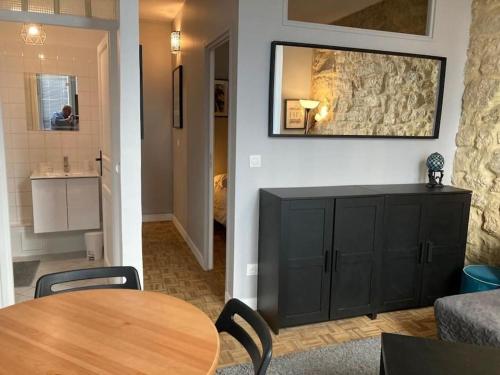 un salon avec une table de salle à manger et une cuisine dans l'établissement Joli appartement à Saint Paul, à Paris