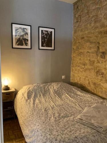 une chambre avec un lit et deux tableaux au mur dans l'établissement Joli appartement à Saint Paul, à Paris