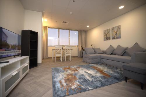 a living room with a couch and a tv and a table at Riggae Tower Hotel in Kuwait