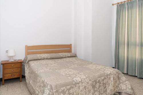 a bedroom with a bed and a table with a lamp at Estirpe, 3º-6 in Cullera