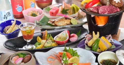Shiga Grand Hotel في يامانوتشي: طاولة مع العديد من الأطباق من المواد الغذائية والمشروبات