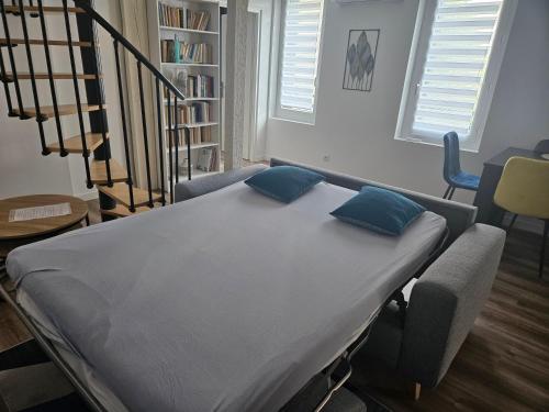 łóżko szpitalne z niebieskimi poduszkami w pokoju w obiekcie Duplex - Palais de Justice w Tuluzie