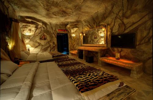 Zimmer mit 2 Betten in einer Steinhöhle in der Unterkunft Caves Beach Resort Adults Only in Hurghada
