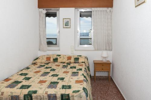 um quarto com uma cama e duas janelas em Florazar 2, Ix-7-B em Cullera
