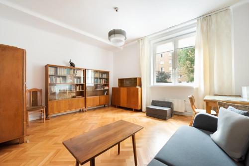 een woonkamer met een bank en een tafel bij Plac Zbawiciela 3-Bedroom Apartment in Warschau
