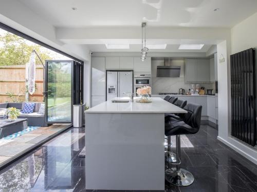 a kitchen with a white island in the middle of a room at Gorgeous Family Home Near River Thames-Old Windsor - Pass the Keys in Windsor