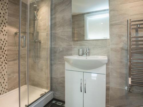 La salle de bains est pourvue d'un lavabo et d'une douche. dans l'établissement Pass the Keys Spacious 3 Bed by River Thames Old Windsor, à Windsor
