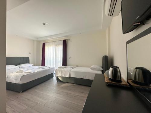 pokój hotelowy z 2 łóżkami i telewizorem w obiekcie Şirin Garden Ayvalık w mieście Ayvalık