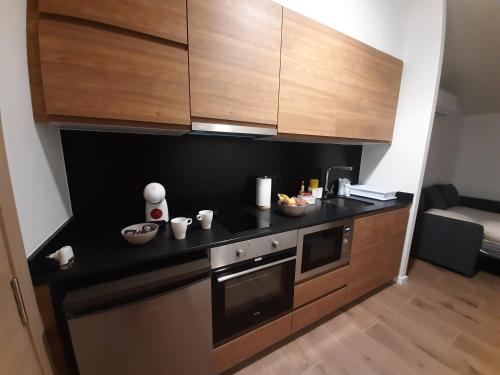 a kitchen with a black counter top and wooden cabinets at Apartaments Vall del Corb 1 Garrotxa in San Miguel del Corp