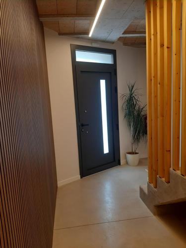 a hallway with a black door and a potted plant at Apartaments Vall del Corb 1 Garrotxa in San Miguel del Corp