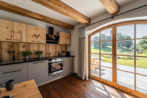 a kitchen with wooden ceilings and a large window at Heimelei in Ettendorf