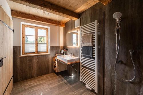 ein Bad mit einem Waschbecken und einer Dusche in der Unterkunft Heimelei 