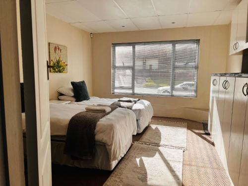 um quarto com 2 camas e uma janela em The White House em Port Elizabeth