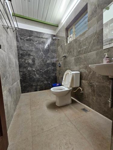 a bathroom with a toilet and a sink at Farmhouse with Pool - Kalavady Farmstay in Baindūru