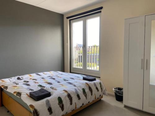 a bedroom with a bed and a large window at Residence Gilze in Gilze