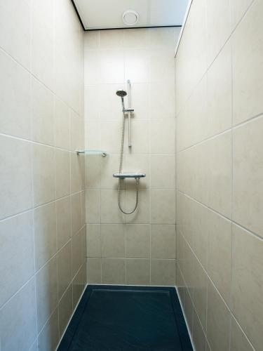 a shower with a black mat in a bathroom at Vakantiewoningen Ut Tumpke in Kessel