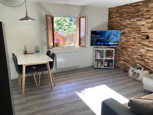 a living room with a table and a tv at Ferienwohnung Morgengruss in Sankt Niklaus