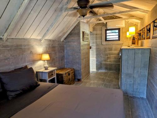 1 dormitorio con 1 cama y ventilador de techo en Chalet De Tahiti, en Punaauia