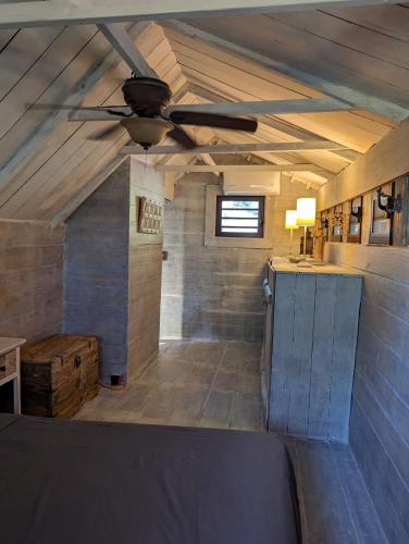 a room with a ceiling fan and a counter in a room at Chalet De Tahiti in Punaauia