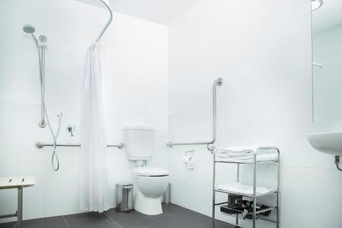 biała łazienka z toaletą i umywalką w obiekcie Quest Werribee w mieście Werribee