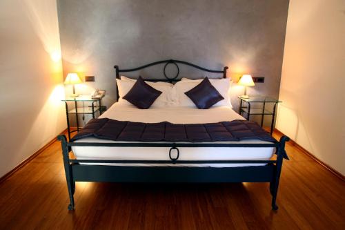 a bedroom with a large bed with two lamps at Hotel San Rocco in Muggia
