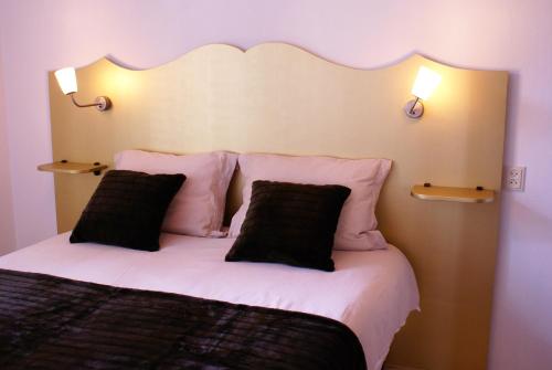 sypialnia z dużym łóżkiem z 2 czarnymi poduszkami w obiekcie Appartement Opa's Huisje w mieście Ruinerwold