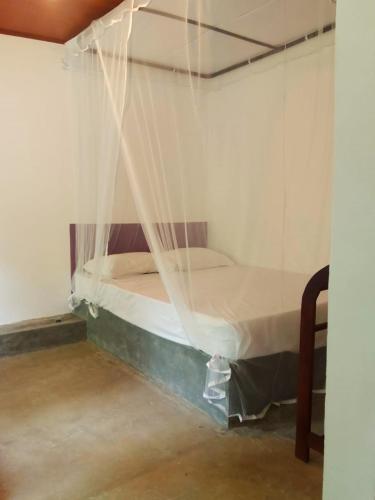 a bed in a room with a net at AB Nest Hiriketiya in Dickwella