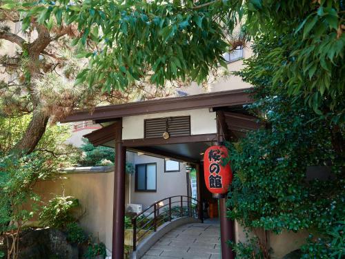 an entrance to a building with a sign on it at Sakura no Yakata Hotel in Fuefuki