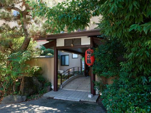 an entrance to a building with a sign on it at Sakura no Yakata Hotel in Fuefuki