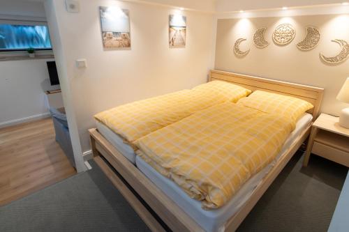 a bedroom with a bed with a yellow blanket on it at Neue zentrale Souterrain-Wohnung 24h Self Check-In in Hamburg