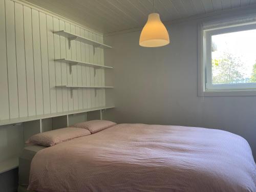 - une chambre avec un grand lit et une fenêtre dans l'établissement Fin Sentralt Hybel i Drammen, à Drammen