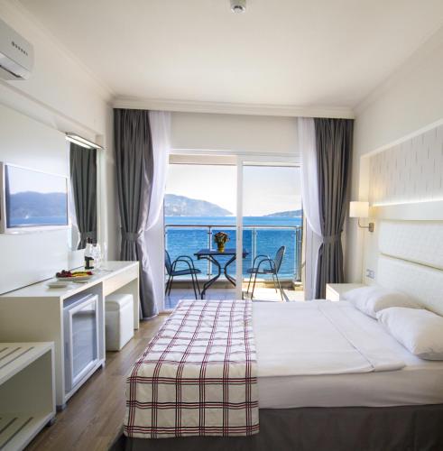 a hotel room with a bed and a view of the ocean at Yunus Beach Hotel in Marmaris