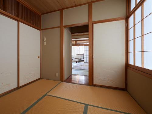an empty room with doors and a room with a table at Sakura no Yakata Hotel in Fuefuki