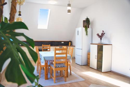 cocina con mesa, sillas y nevera en Luxus Apartment! Küche, Balkon, Netflix, Parkplatz - 8 Personen, en Ilmmünster