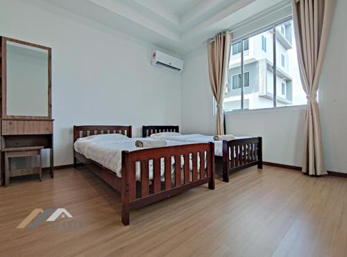 a bedroom with two beds and a large window at Serene Heights by Evernent in Miri