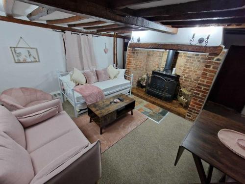 ein Wohnzimmer mit Couch und Kamin in der Unterkunft Two Bedroom Grade ll Cottage At AZ Luxury Stays Honey Horsefield With WiFi And Free Parking in Hundon