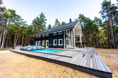 uma casa preta com uma piscina num deque de madeira em Dirhami Pool Villa em Dirhami