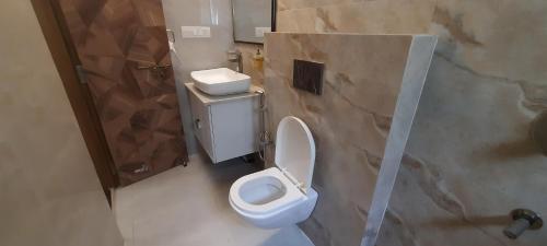 a bathroom with a white toilet and a shower at The Candy Nest in Rānchī