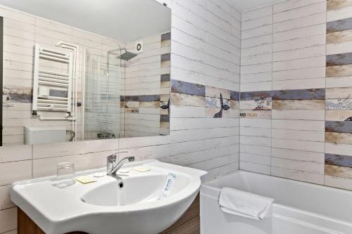 ein weißes Badezimmer mit Waschbecken und Badewanne in der Unterkunft Hotel Aqua Park in Eforie Nord