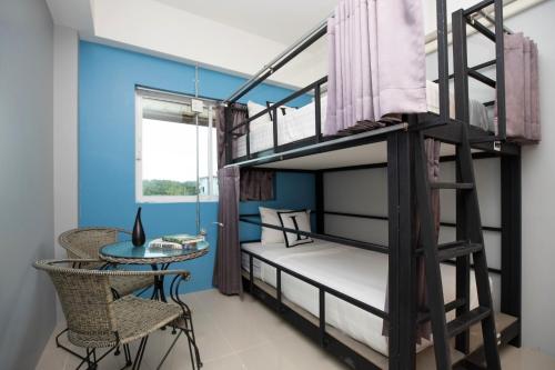 Bell Lifestyle Hostel Phuket في شاطئ ناي يانغ: غرفة مع سرير بطابقين وطاولة