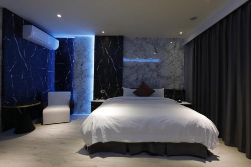 a bedroom with a white bed and blue lighting at MY Motel in Mingjian