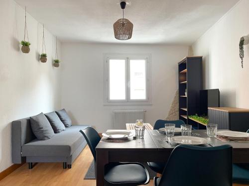 a living room with a table and a couch at Charmant duplex - Narbo Appart in Narbonne
